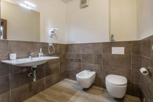 a bathroom with a sink and a toilet and a mirror at Appartamento Fiocco in Malcesine +18 photos