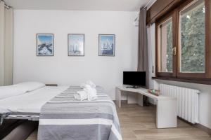 a bedroom with a bed and a desk with a television at Appartamento Fiocco in Malcesine