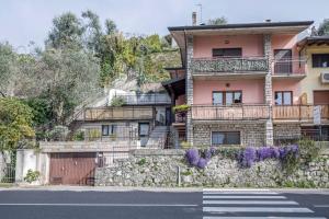a house on a hill with a stone wall at Appartamento Fiocco in Malcesine