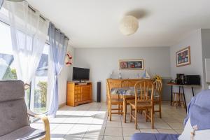 a bedroom with a bed and a table and chairs at La Mouette St Philibert 3 étoiles in Saint-Philibert