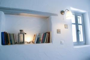 a shelf with books on a wall with a window at House with private pool in Naousa