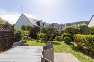 a wooden walkway leading to a yard with houses at La Mouette St Philibert 3 étoiles in Saint-Philibert