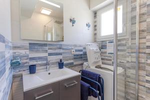 a bathroom with a sink and a washing machine at La Mouette St Philibert 3 étoiles in Saint-Philibert +23 photos