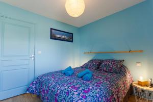 a bedroom with a bed with blue walls at La Mouette St Philibert 3 étoiles in Saint-Philibert
