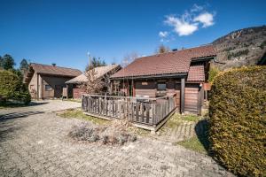 a home with a wooden porch and a house at Chalet 6p - Le casse noisette in Verchaix