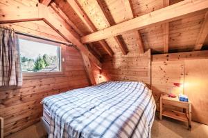 a bedroom with a bed in a wooden cabin at Chalet 6p - Le casse noisette in Verchaix