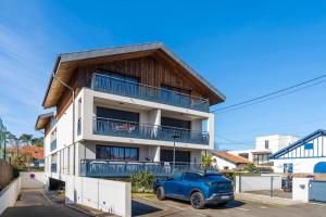a house with a blue car parked in front of it at Imarena, Elegance et Vue Port in Capbreton