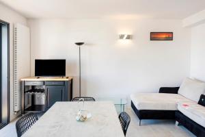 a living room with a table and a couch at Imarena, Elegance et Vue Port in Capbreton