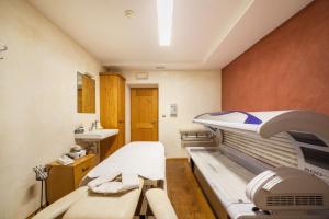 a hospital room with a hospital bed and a sink at Alpenhof Lodge Almrose in Saltusio