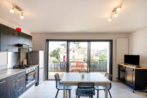 a kitchen with a table and chairs in a kitchen at Imarena, Elegance et Vue Port in Capbreton