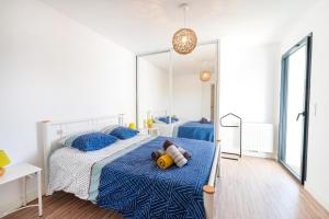 a bedroom with two beds and a large mirror at Imarena, Elegance et Vue Port in Capbreton