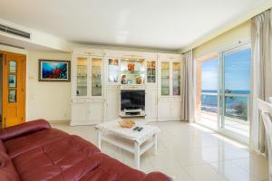 a living room with a couch and a table at Frente al mar in Cala Millor