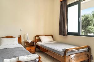 two beds in a room with a window at Daratos studio 4 in Kefallonia