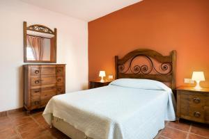 a bedroom with a bed and two dressers and a mirror at Casa Juana Zahora in Zahora +17 photos