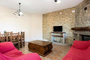 a living room with red chairs and a fireplace at Casa Juana Zahora in Zahora