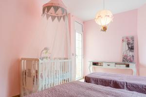 a baby room with a crib and a pink bedroom at Villa Yulia in Vidreres +20 photos