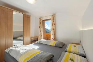 a bedroom with two beds and a mirror at Burgerhof in Gsies