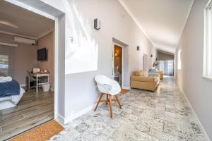 a living room with a white chair and a couch at Orange Blossom Grove in São Bartolomeu de Messines