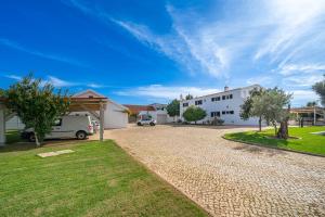 a driveway in front of a white house at Orange Blossom Grove in São Bartolomeu de Messines