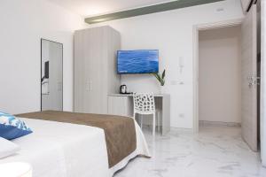a white bedroom with a bed and a desk at Fantasia House in Marsala