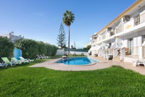 a swimming pool in a yard next to a building at Villa Martina in Albufeira