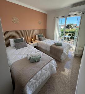 two beds in a room with a balcony at Villa Martina in Albufeira +31 photos