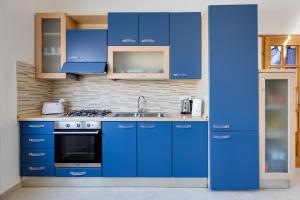 a blue kitchen with a sink and a stove at Casa Simo in Porto Alabe