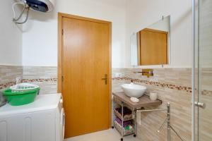 a bathroom with a sink and a wooden door at Casa Simo in Porto Alabe +16 photos