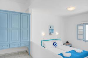 a white room with a bed and a blue cabinet at Pico Bello Patmos 28 in Patmos