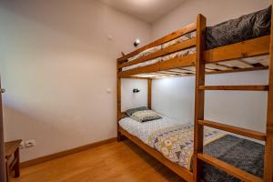 a bedroom with two bunk beds and a ladder at Le calme de Ax in Ax-les-Thermes