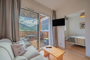 a living room with a couch and a balcony at Le calme de Ax in Ax-les-Thermes