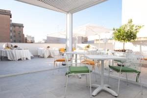 a patio with tables and chairs on a roof at Fantasia House in Marsala