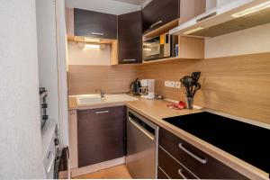 a small kitchen with wooden cabinets and a sink at Le calme de Ax in Ax-les-Thermes +12 photos
