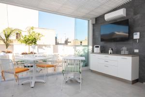 a kitchen with a table and chairs and a tv on a wall at Fantasia House in Marsala