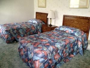 a hotel room with two beds and a lamp at Eagle Village Resort & Chalet in Bushkill