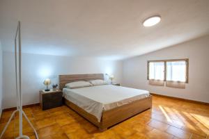 a bedroom with a large bed and a wooden floor at Villa Giovanna in Sorso