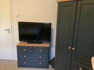 a tv on a dresser next to a black cabinet at Bohlen Rhede in Rhede
