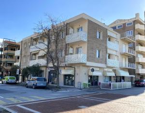 a building on a street with cars parked in front of it at A7 Trilocale Fronte Mare in Marina di Grosseto