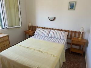a small bedroom with a bed and a mirror at Una casa sulla spiaggia in Es Grau