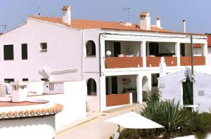 a white apartment building with a balcony at Una casa sulla spiaggia in Es Grau