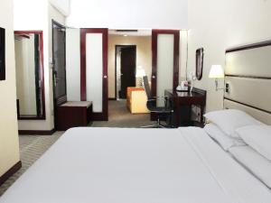 a bedroom with a bed and a desk and a computer at Dorsett Putrajaya in Putrajaya