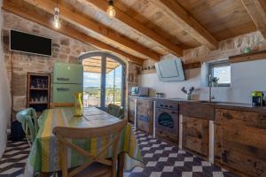 a kitchen with a table and a refrigerator at Trulli Tower in Putignano
