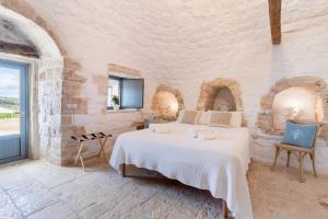 a bedroom with a bed in a stone wall at Trulli Tower in Putignano +33 photos