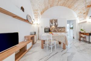 a kitchen and dining room with a table and a television at Rosy Maison in Squinzano