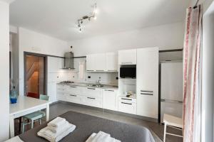 a kitchen with white cabinets and a table and a refrigerator at Ce Tour - Cetara Guest House in Cetara