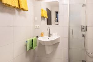 a white bathroom with a sink and a shower at Ferienwohnung Lago in Konstanz +14 photos