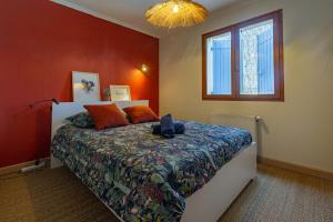 a bedroom with a bed with orange walls and a window at Maison dans la Drôme Piscine privée in Montélimar +24 photos