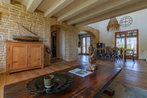 a living room with a table and a stone wall at Maison dans la Drôme Piscine privée in Montélimar