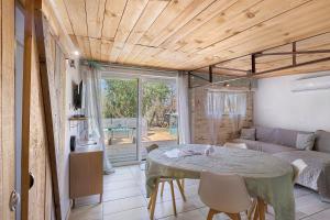a living room with a table and a couch at Chalet de Ferme - Spa - Gironde in Les Églisottes-et-Chalaures