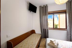 a small bedroom with a bed and a window at Barrinha Beach in Esmoriz